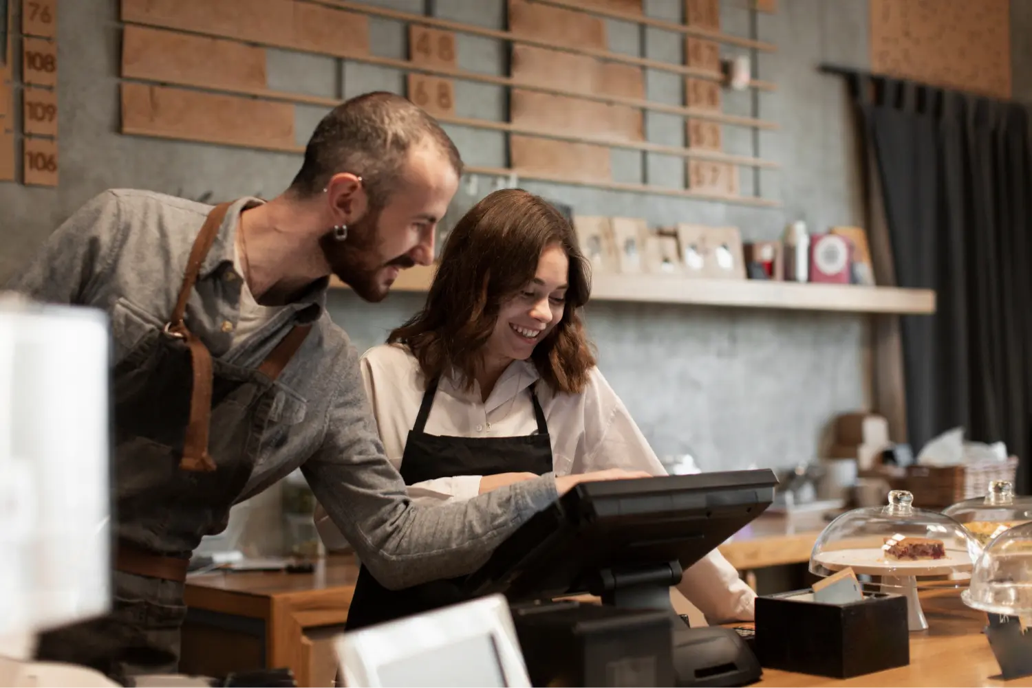 Two cafe employees working at a POS terminal