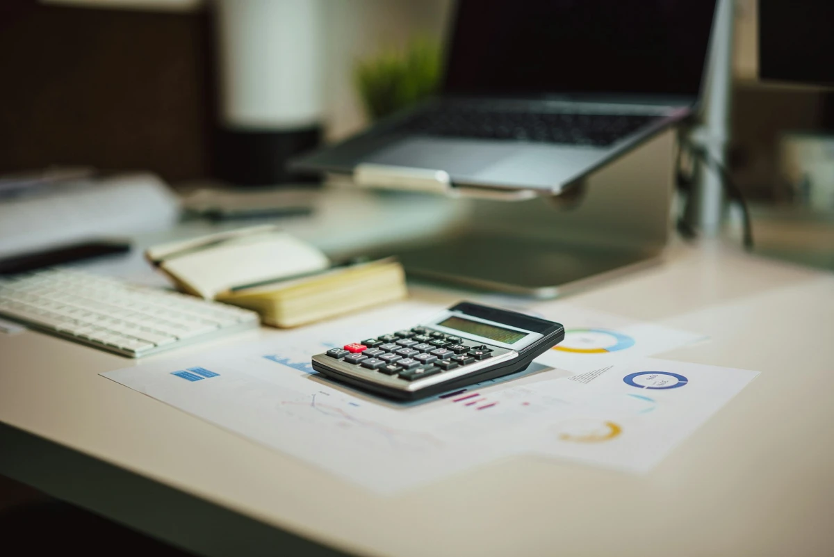 A calculator and financial charts used to calculate loyalty program ROI