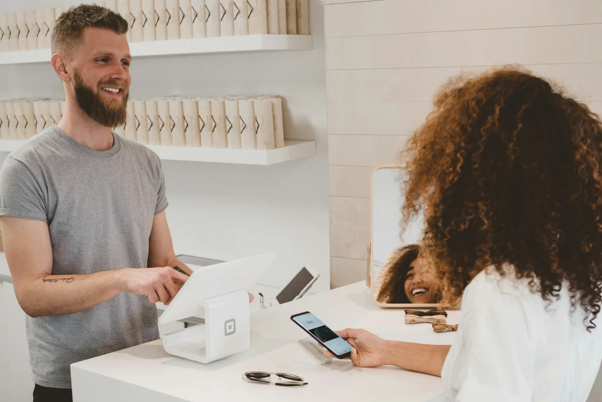 A customer pays by smartphone at a store checkout