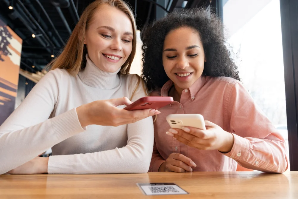 Two friends share a referral invitation using their smartphones