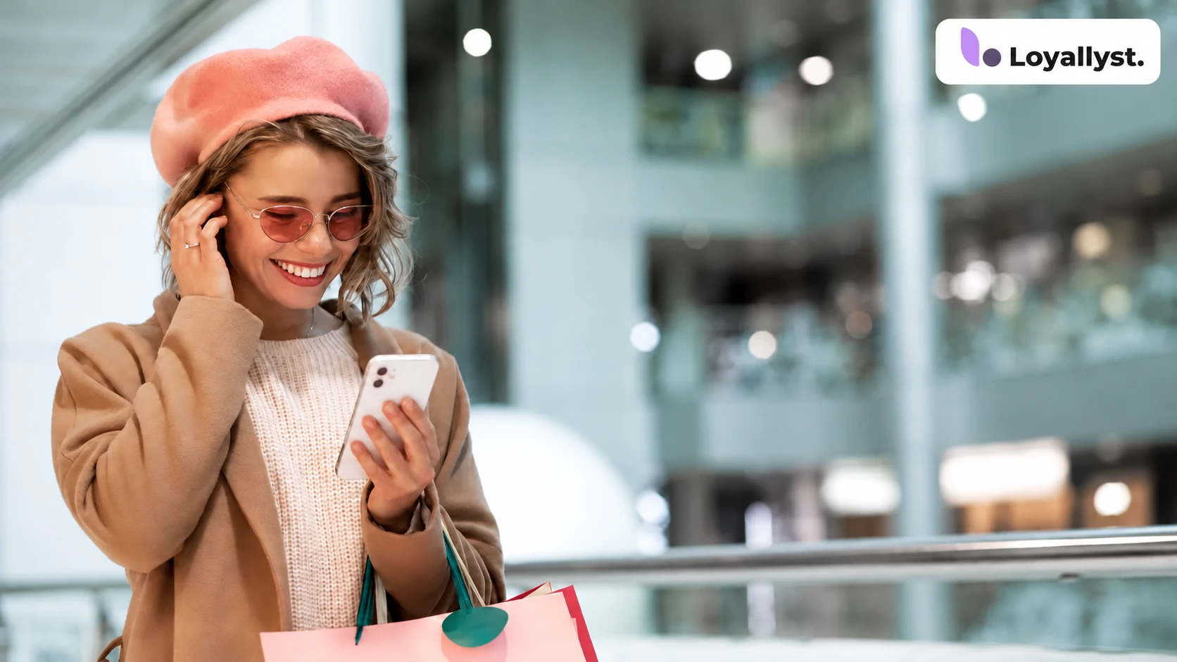 A shopper with a phone and shopping bags; the Loyallyst logo is in the upper-right corner
