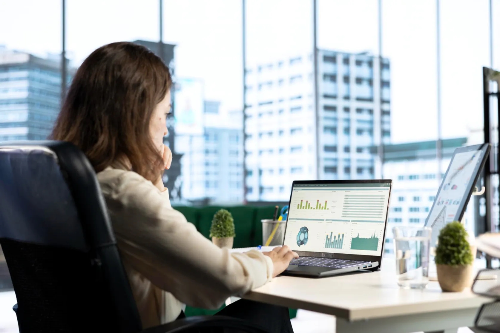 A woman analyzes customer data in a CRM on her laptop