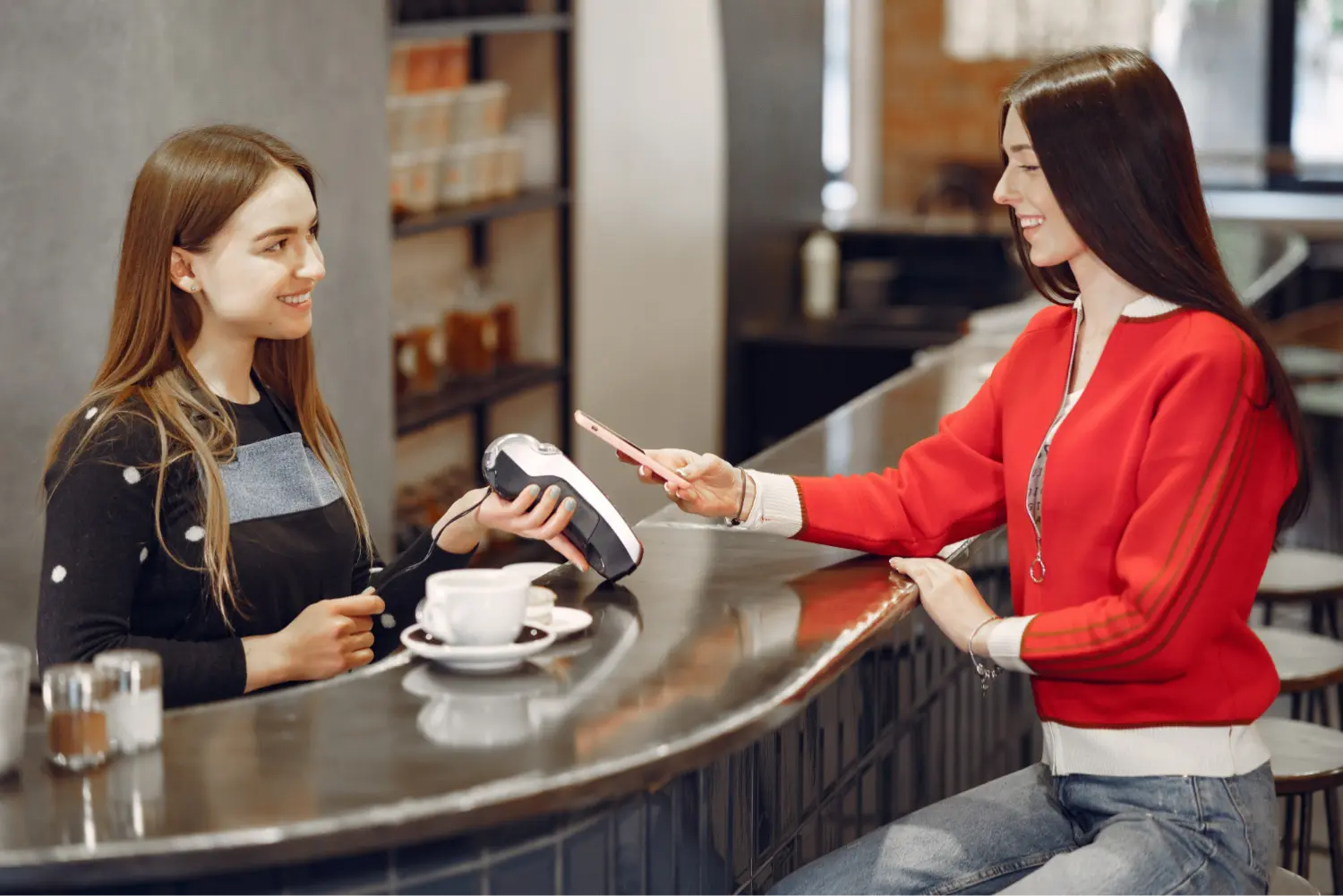 A café employee scans a customer’s phone loyalty card at checkout